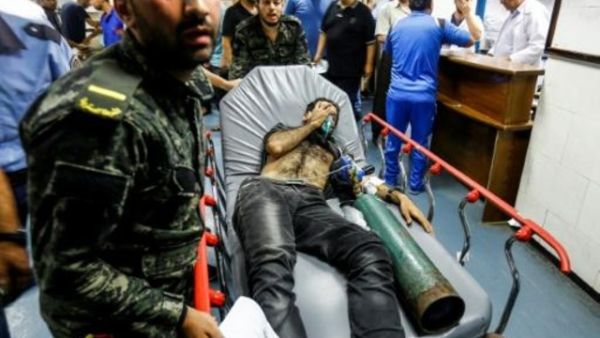 عناصر في حركة حماس ينقلون فلسطينيا اصيب في الغارات الاسرائيلية لتلقي عناية طبية في مستشفى الشفاء في غزة
