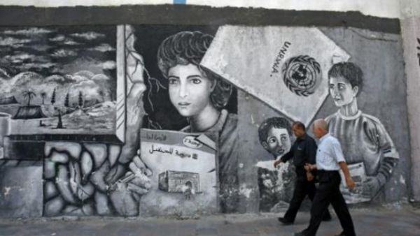 رجلان فلسطينيان أمام المركز الرئيسي لوكالة الاونروا في قطاع غزة
