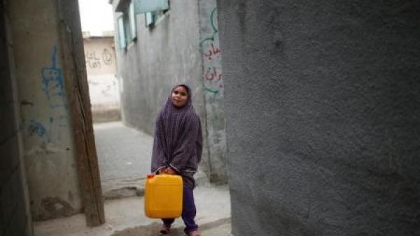 فتاة فلسطينية تحمل مياه في علبة بلاستيكية في شمال غزة
