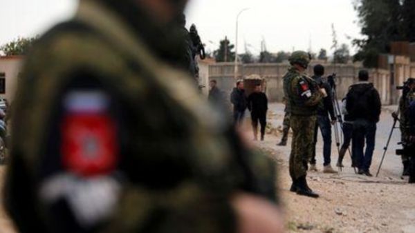 جنود روس يقومون بتأمين منطقة ينتظر فيها صحفيون مرور قافلة مساعدات عائدة من الغوطة الشرقية
