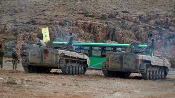 مقاتلون تابعون لحزب الله يرافقون حافلات في جرود عرسال في لبنان
