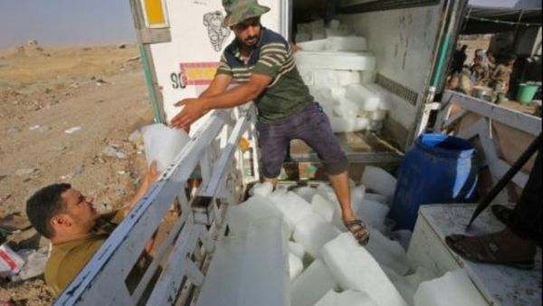 عراقيون يفرغون قوالب ثلج من شاحنة في تل عبطة جنوب تلعفر لتسليمها للمقاتلين العراقيين الذين يواجهون تنظيم الدولة الإسلامية على خطوط الجبهة في شمال العراق


