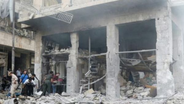 مواطنون سوريون يتفقدون الاضرار بعد ضربة جوية على سوق خضار في معرة النعمان في محافظة ادلب
