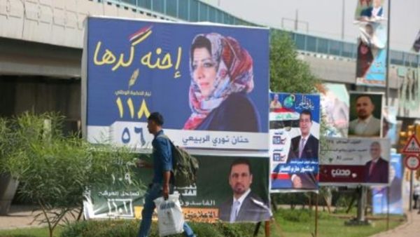 رجل يمر امام لافتة انتخابية في بغداد للمرشحة حنان نوري الربيعي.

