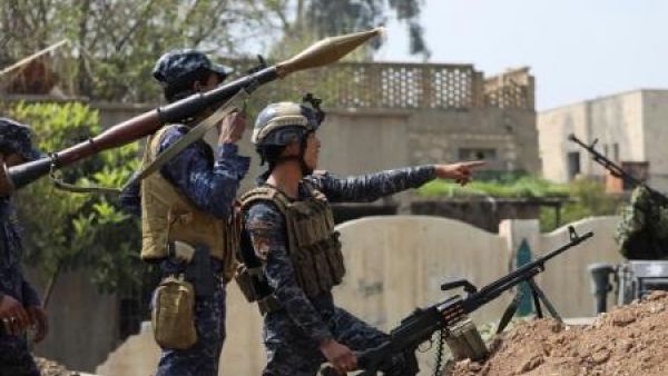 اثنان من أفراد الشرطة الاتحادية العراقية ينظران إلى مواقع للدولة الإسلامية
