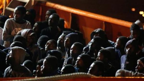 مهاجرون في انتظار نزولهم من على سفينة في ميناء أوجستا بصقلية في إيطاليا
