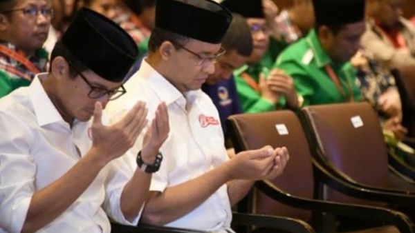 أنيس باسويدان (الثاني من اليسار) يصلي إلى جانب نائبه ساندياغا أونو (يسار) خلال مناسبة نظمتها لجنة الانتخابات

