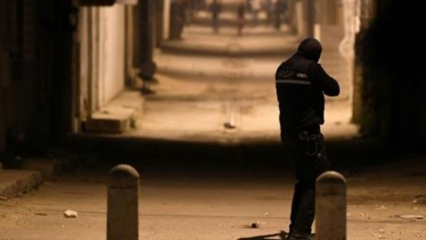 احد افراد قوات الامن التونسية يواجه محتجين في حي التضامن ضاحية العاصمة
