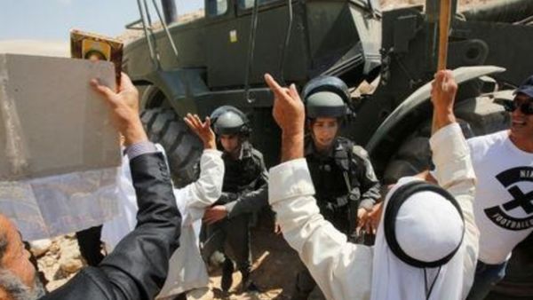 فلسطينيون وأجانب يتصدون لجرافة إسرائيلية قرب قرية الخان الأحمر بالضفة الغربية المحتلة
