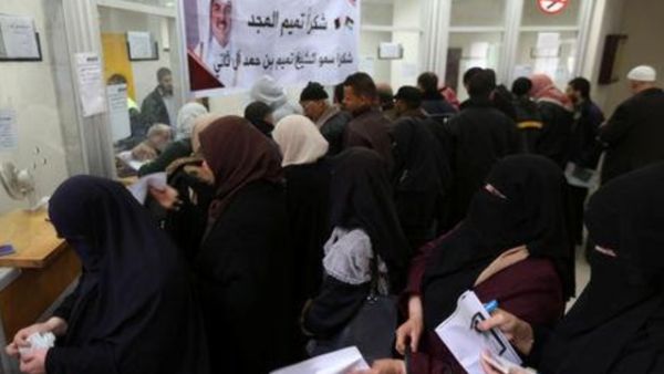 موظفون فلسطينيون مُعينون من قبل حماس ينتظرون لصرف رواتبهم المقدمة من قطر في خان يونس يوم الجمعة
