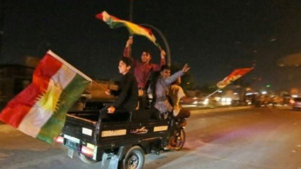 عراقيون أكرد يلوحون بالاعلام الكردية أثناء مرورهم في مواكب سيارة في شوارع كركوك في شمال العراق
