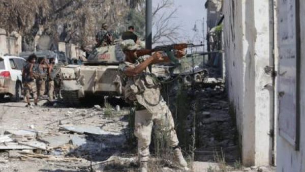 أحد أفراد الجيش الوطني الليبي يطلق النار أثناء اشتباك مع مقاتلين إسلاميين في معقلهم الأخير في بنغازي يوم الخميس
