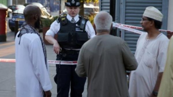 شرطية تتحدث الى مقيمين في حي فينسبوري بارك بشمال لندن بعد دهس شاحنة لمارة بالقرب من مسجد
