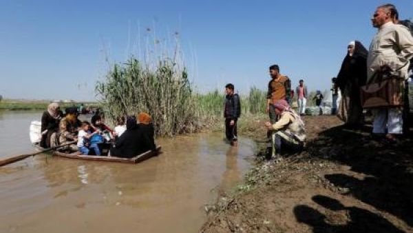 قارب يقل فارين من الموصل عبر نهر دجلة
