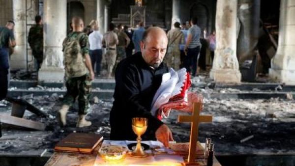 مسيحي عراقي يعد لإقامة قداس في كنيسة الطاهرة الكبرى في بلدة قرة قوش قرب الموصل
