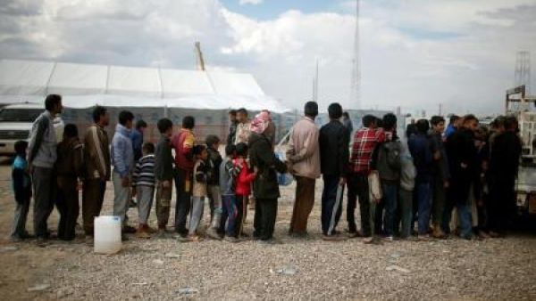 نازحون عراقيون فارون من منازلهم ينتظرون الحصول على الطعام قبل دخول مخيم حمام العليل جنوب الموصل
