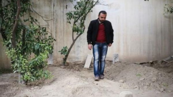 صديق لعائلة رياض بين قبور بعض افرادها في الحديقة بانتظار مواراتهم الثرى في مكان آخر

