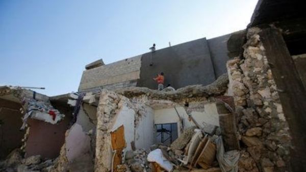 عمال يقومون بترميم منزل في الموصل
