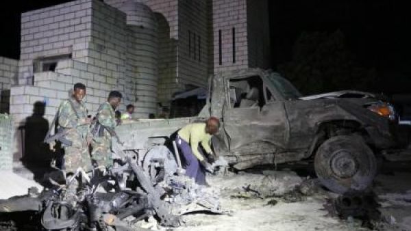 جنود ورجال شرطة صوماليون يعاينون موقع هجوم إنتحاري بسيارة ملغومة قرب البرلمان في العاصمة مقديشو يوم السبت
