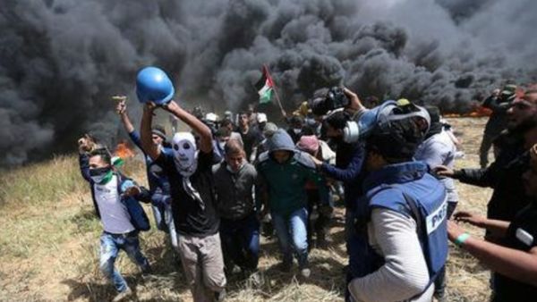 فلسطينيون يقومون بإجلاء الصحفي الفلسطيني ياسر مرتجى الذي أصيب بجروح مميتة أثناء تغطية الاشتباكات على الحدود بين إسرائيل
