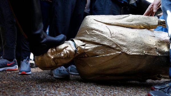 امراة تدوس التمثال بقدمها

