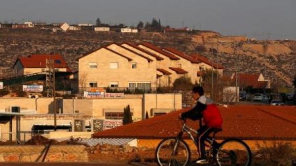 صبي يستقل دراجة ويمر عبر منازل في مستوطنة عوفرا الاسرائيلية في الضفة الغربية 

