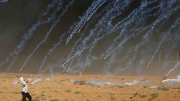 قنابل غاز مسيل للدموع ألقتها قوات إسرائيلية على محتجين فلسطينيين على الحدود مع غزة يوم الجمعة

