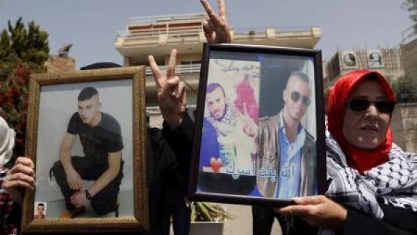 فلسطينيون يرفعون صور أقاربهم المضربين عن الطعام في السجون الإسرائيلي في احتجاج للتضامن معهم في القدس الشرقية
