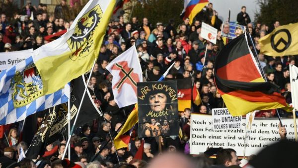 Supporters of the Pegida movement (Patriotic Europeans Against the Islamization of the Occident) hold placards featuring Angela Merkel in Dresden, eastern Germany, on February 6, 2016. (AFP/Tobias Schwarz)