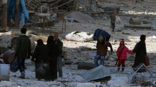 أشخاص يسيرون وسط حطام مبان مدمرة في شرق حلب
