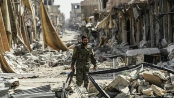 عنصر من قوات سوريا الديموقراطية يجول بين أنقاض الحي القديم في الرقة

