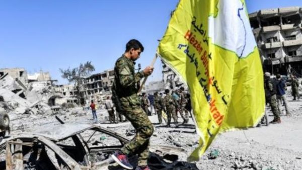 مقاتل من قوات سوريا الديمقراطية يغرس علم القوات الأصفر في ساحة في الرقة كان تنظيم الدولة الاسلامية يستخدمها في تنفيذ عمليات اعدام وصلب وتعليق جثث اثناء سيطرته على المدينة.

