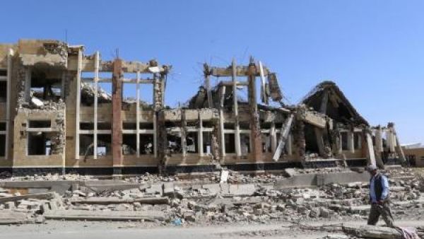 رجل يمر بجانب مبنى دمرته ضربات جوية لقوات التحالف التي تقودها السعودية في شمال غرب مدينة صعدة باليمن 

