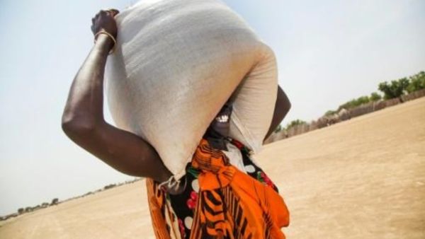 امرأة تحمل كيس مساعدات غذائية تم توزيعها في غانييل، بمنطقة بانييجيار بجنوب السودان

