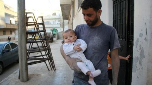 السوري يحيى معتوق يحمل طفلته وحيدة في ادلب

