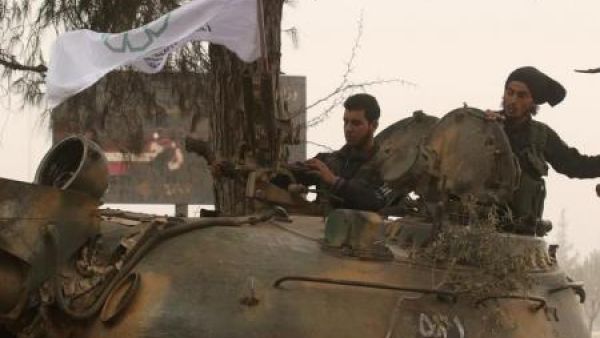 مقاتلان من المعارضة السورية فوق مركبة عسكرية في غرب حلب
