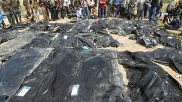 عراقيون ينتحبون قرب اكياس جثث يعتقد انها تحتوي رفات اشخاص قتلوا على ايدي جهاديي تنظيم الدولة الاسلامية في مخيم سبايكر في تكريت

