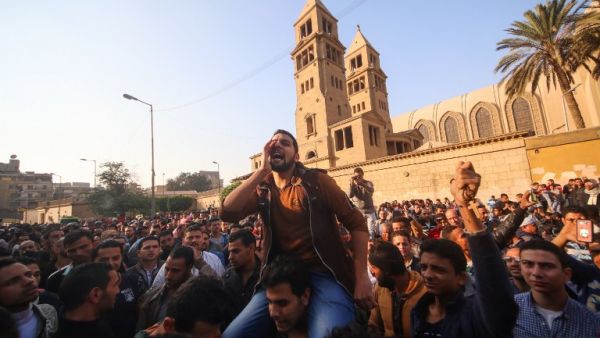 Egyptians shout slogans as they gather outside the the Saint Peter and Saint Paul Coptic Orthodox Church in Cairo's Abbasiya neighborhood after it was targeted by a bomb explosion on December 11, 2016. (AFP/Mohamed Muteab) Egyptians shout slogans as they gather outside the the Saint Peter and Saint Paul Coptic Orthodox Church in Cairo's Abbasiya neighborhood after it was targeted by a bomb explosion on December 11, 2016. (AFP/Mohamed Muteab)
