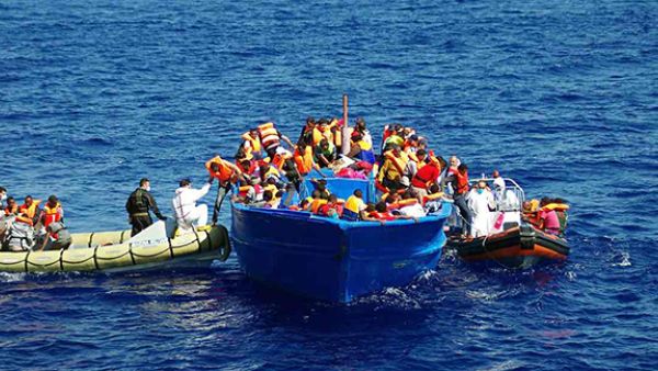 Italian navy rescuers help refugees to climb on to their boat in the Mediterranean. (AFP/Getty Images)