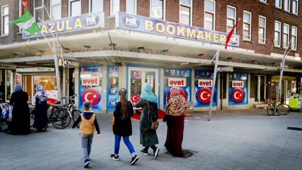 People walk past Turkey's upcoming referendum campaign posters reading "Yes" in Turkish, on the facade of a building in Rotterdam on March 25, 2017. (AFP/Remko de Waal)