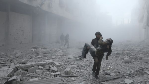 A wounded man is carried following an air strike on the rebel-held town of Erbin in Eastern Ghouta near Damascus on January 2, 2018 ABDULMONAM EASSA/AFP/FILE