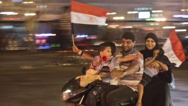 An Egyptian family on motorcycle celebrates in Cairo on July 3 after a broadcast by the head of Egypt's army suspended the constitution (Khaled Desouki / AFP)