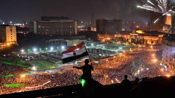 Egyptians wave the national flag on a building rooftop on July 7, 2013 as hundreds of thousands flood Egypt's landmark Tahrir square to demontrate against ousted President Mohammed Morsi and in support of the Egyptian Army in Cairo (Mohamed el-Shahed / AFP)