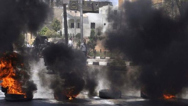 Black smoke rises from tires set on fire by demonstrators outside the Luxor town house protesting against the appointment of Adel al-Khayat (AFP)