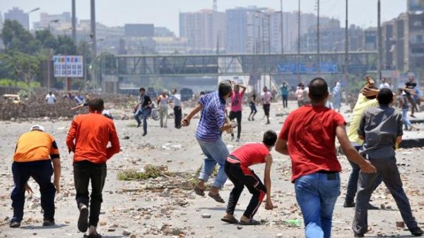 EGYPT, Cairo : Supporters of the Muslim Brotherhood and Egypt's ousted president Mohamed Morsi (foreground) clash with opponents to ousted president Morsi (background) in Cairo on July 27, 2013.  AFP PHOTO/FAYEZ NURELDINE