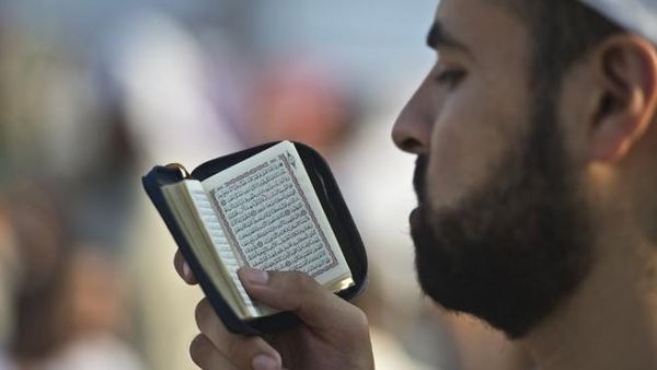 EGYPT, Cairo : A supporter of Egypt's deposed president Mohamed Morsi reads the Koran during a rally calling for his release and re-instatement outside Rabaa al-Adawiya mosque in Cairo on August 4, 2013. AFP PHOTO / KHALED DESOUKI