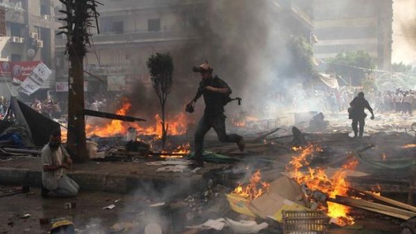 EGYPT, Cairo : Reporters run for cover during clashes between Muslim Brotherhood supporters of Egypt's ousted president Mohamed Morsi, and police in Cairo on August 14, 2013. AFP PHOTO / MOSAAB EL-SHAMY