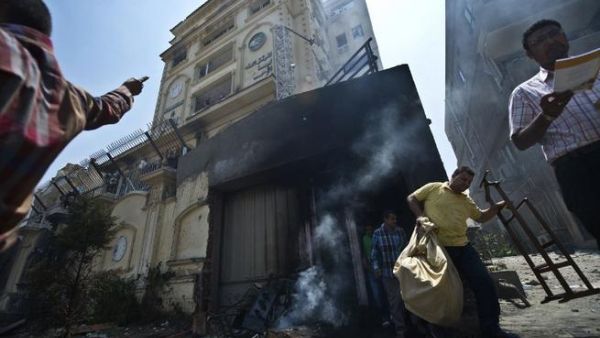 Egyptian men carry items looted from the burnt headquarters of the Muslim Brotherhood (Khaled Desouki / AFP)