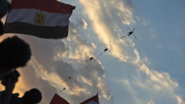 Egyptian army helicopters fly over as hundreds of thousands of Egyptian demonstrators gather outside the presidential palace in Cairo (Khaled Desouki / AFP)