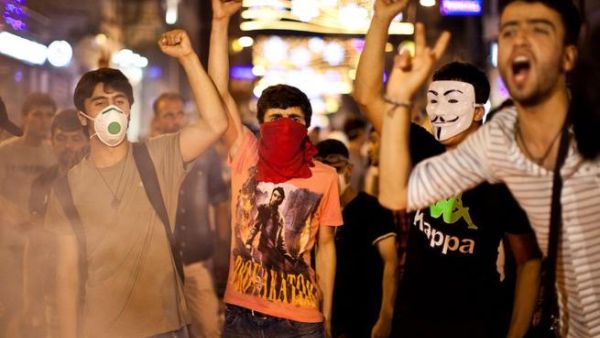 Protestors chant slogans behind a barricade on July 14, 2013 in the center of Istanbul.  AFP PHOTO /GURCAN OZTURK